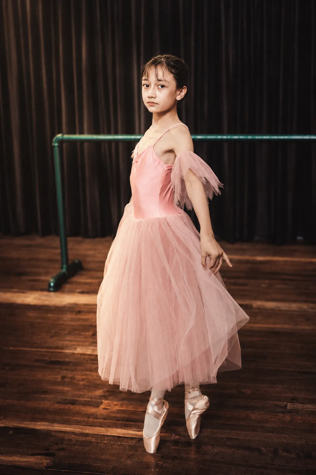 Bailarina en puntas con tutú rosa sobre el escenario